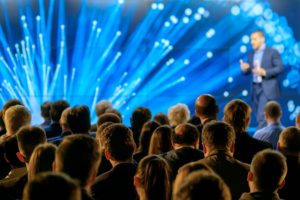 Audience listening to speaker in front of LED screen